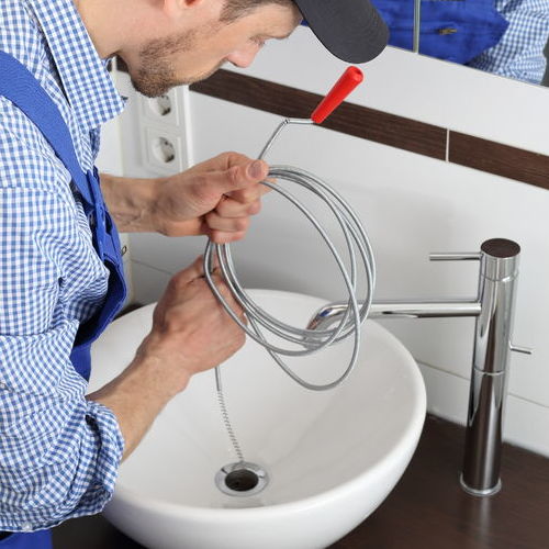 Plumber Uses Drain Augur or Drain Snake to Clean Sink Drain.