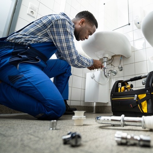 A Plumber Repairs a Bathroom Sink,